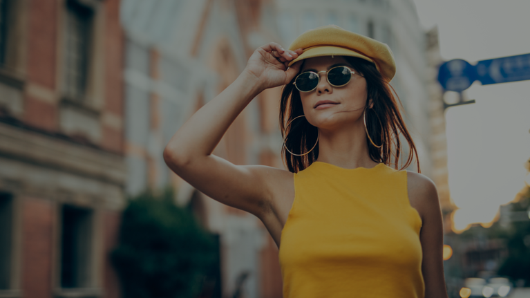 Woman in a yellow outfit standing on a city street